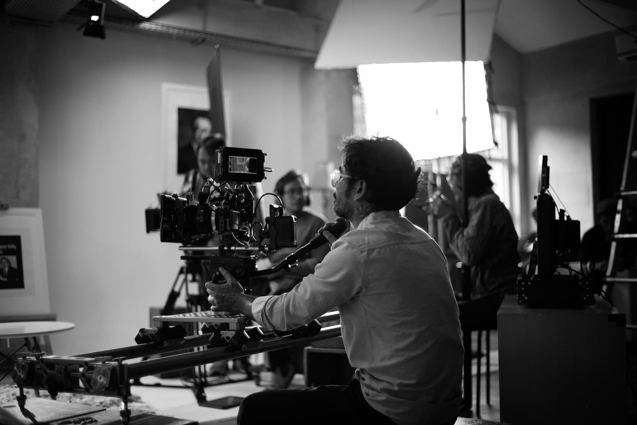 A camera operator working with a cinema camera on a dolly